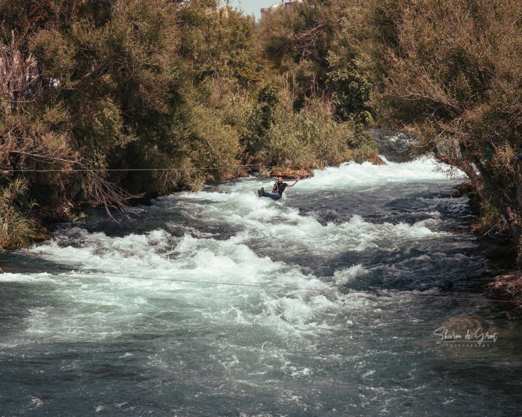 man zip lining across the düden river