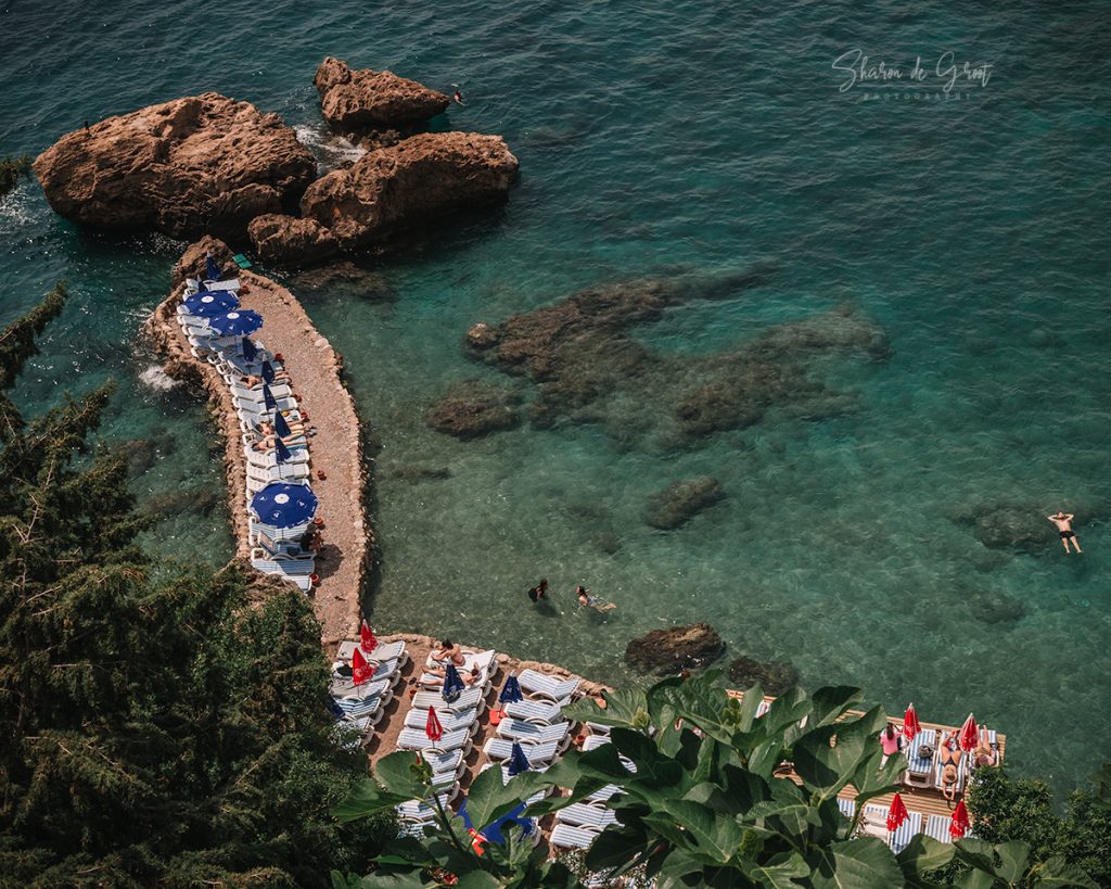 pebble beach seen from above with emerald water