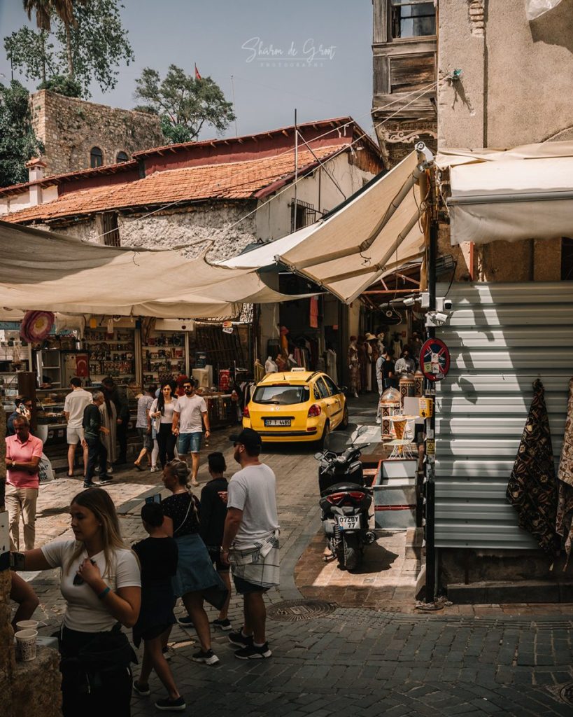 taxi driving through a narrow and busy street in the old town of Anatalya.