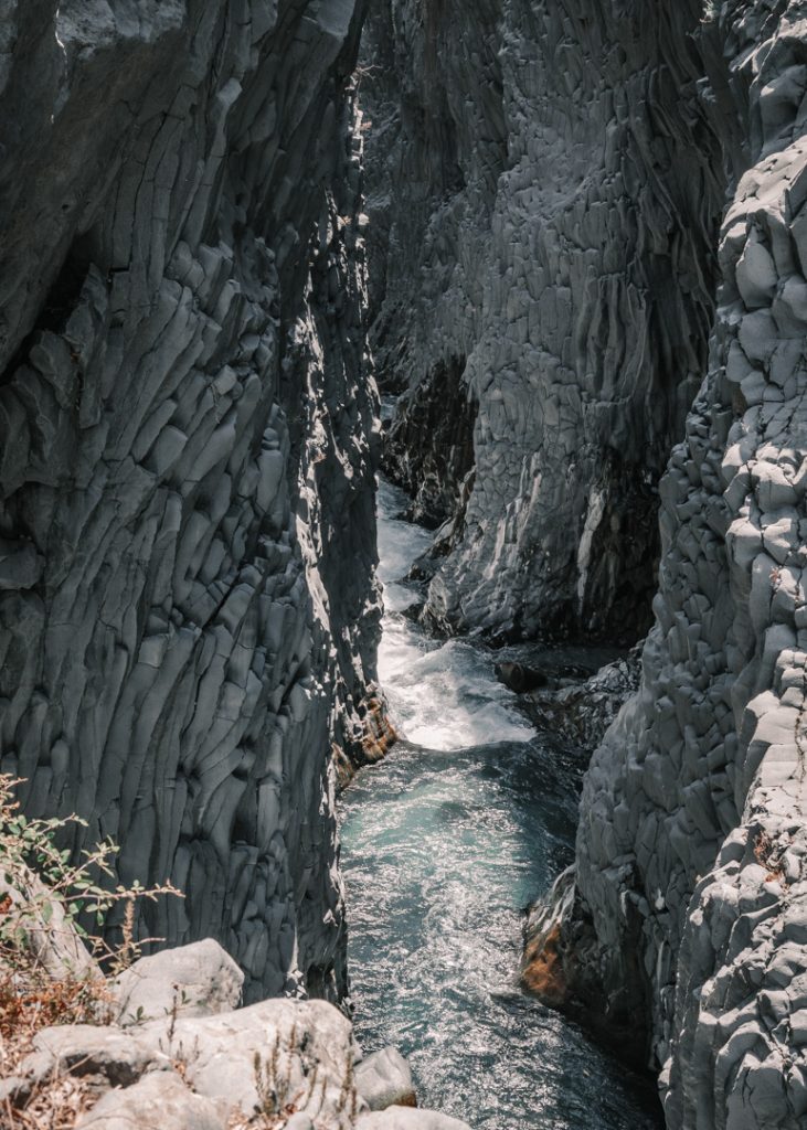 Alcantara gorge: A gorge with ballast rock columns with crystal clear water going through it.