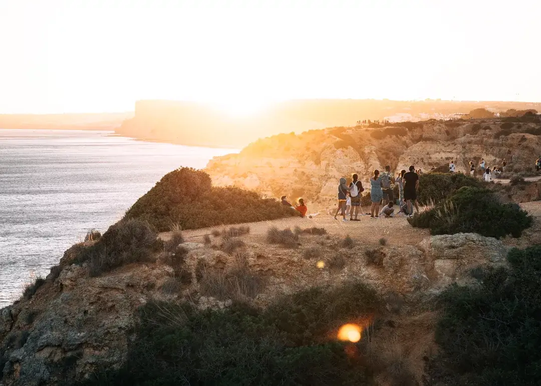 Crowds gathering for sunset on limestone cliffs.